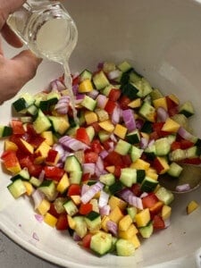 lemon juice being added to bowl of veggies
