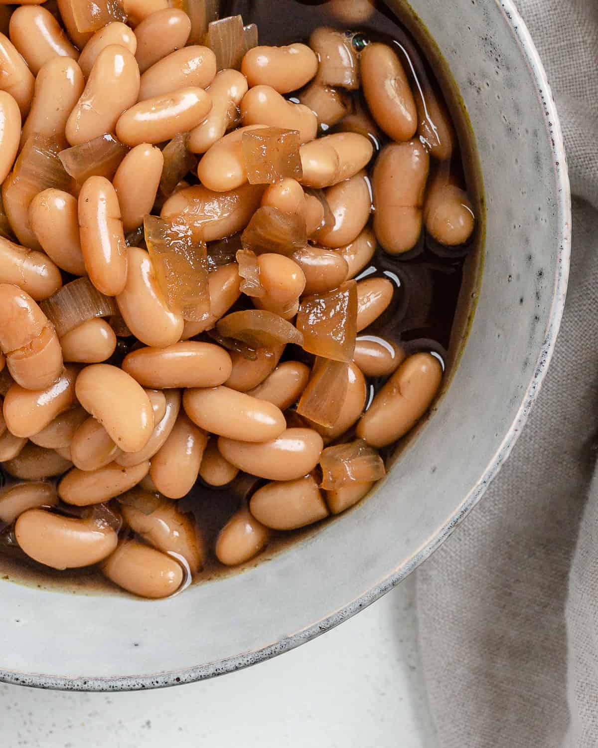 completed Vegan Slow Cooker Baked Beans in a white bowl against a white background