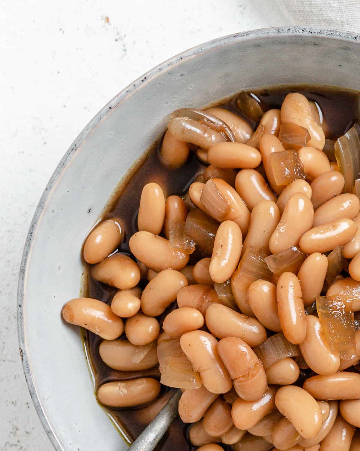 completed Vegan Slow Cooker Baked Beans in a white bowl against a white background