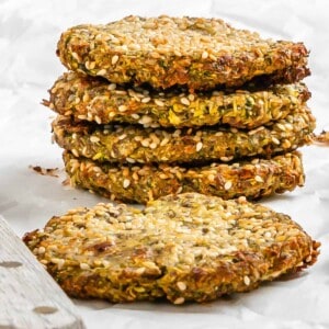 completed stack of Vegan Baked Zucchini Fritters against a white surface