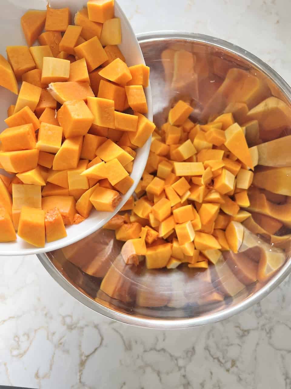 process showing roasted butternut squash being poured into a bowl