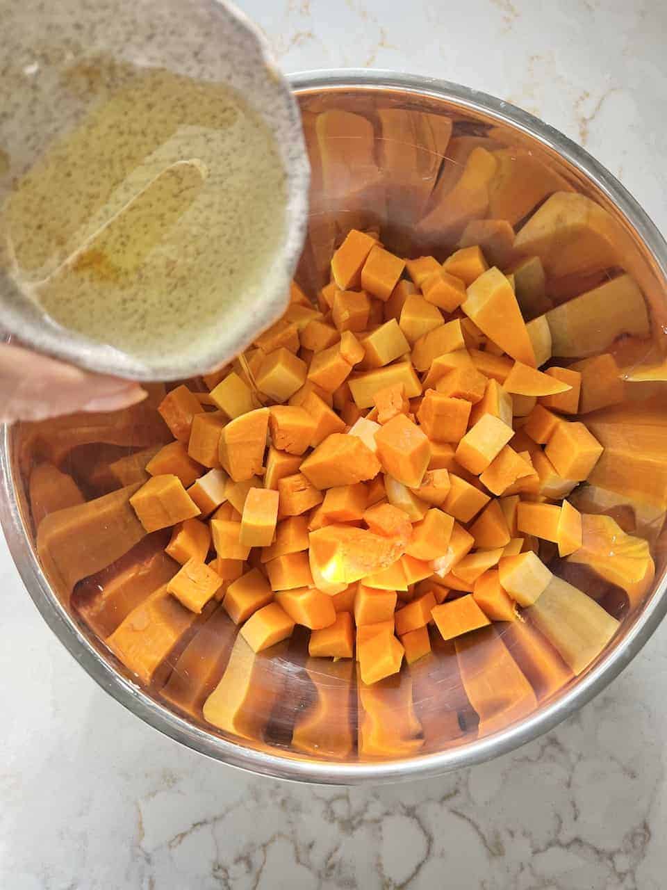 process showing ingredients being poured into roasted butternut squash bowl