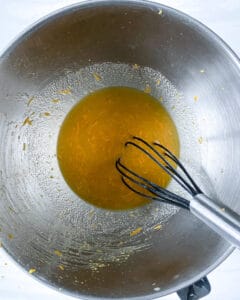 process of Orange Olive Oil Cake wet ingredients being mixed in stainless steel bowl