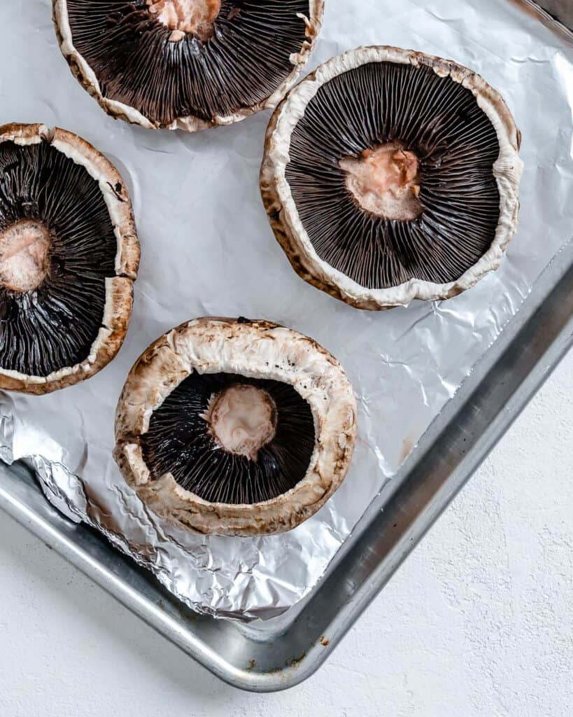 portobello mushrooms on a baking tray lined with parchment paper