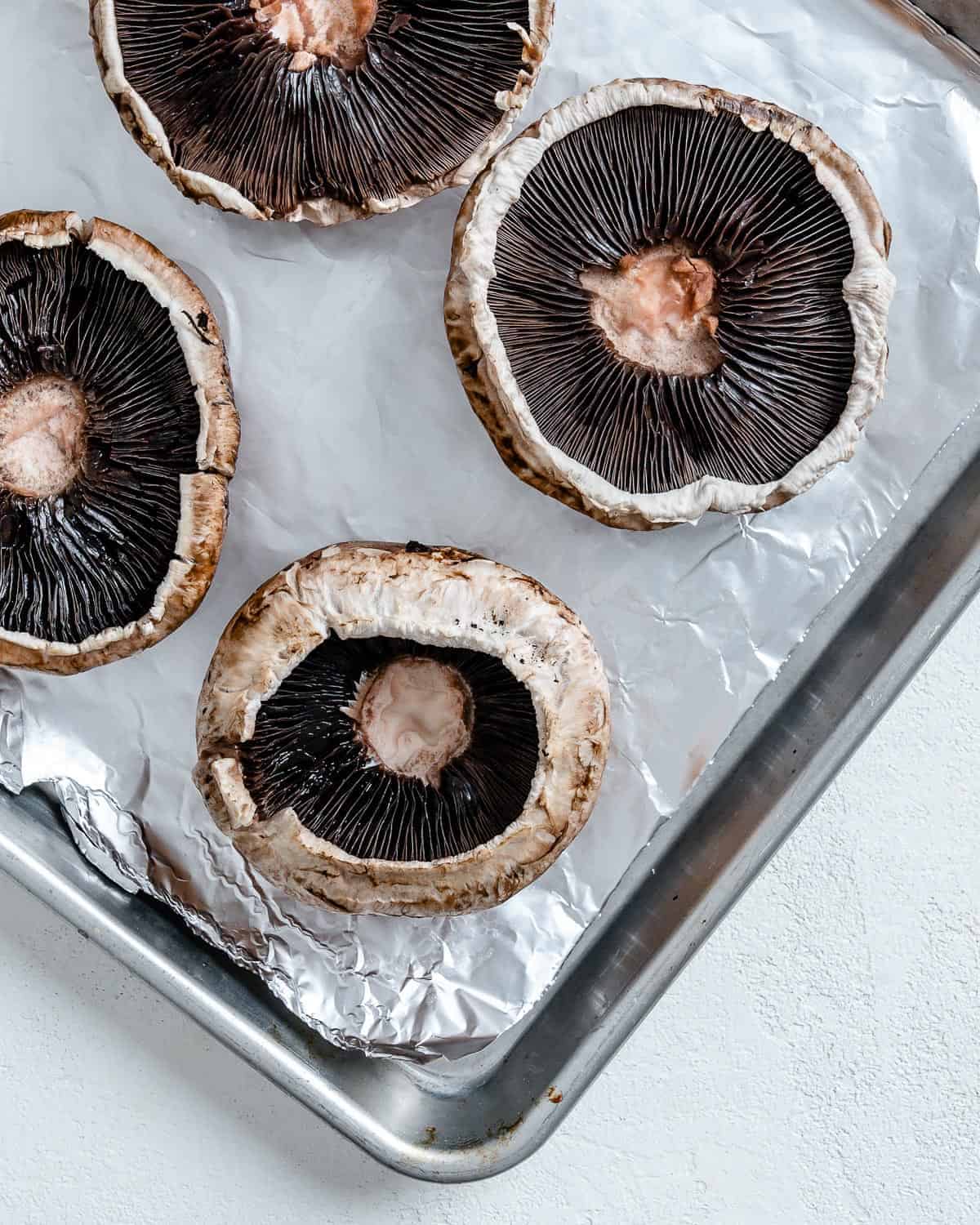 portobello mushrooms on a baking tray lined with parchment paper