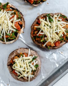 process of adding vegan cheese to Portobello Mushroom Pizzas