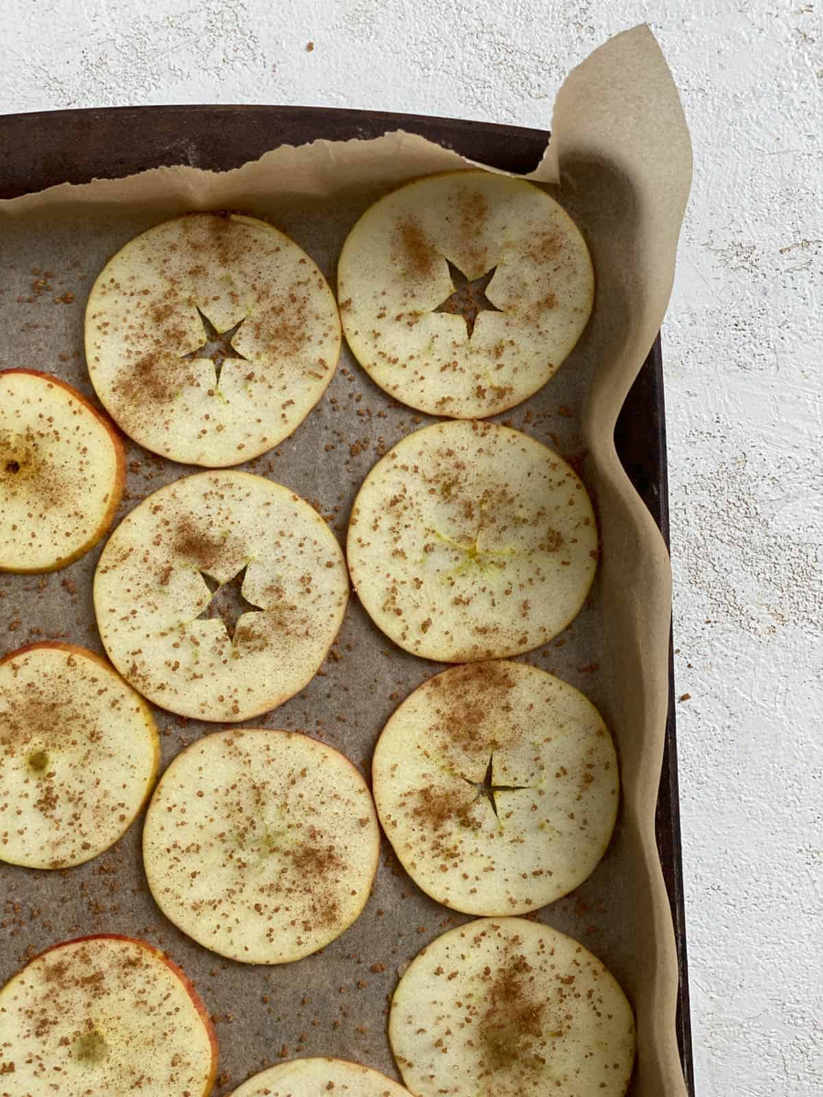 spices spread out on apples on baking tray