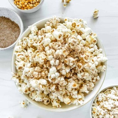 chai popcorn in a big and small bowl with seasonings in the background