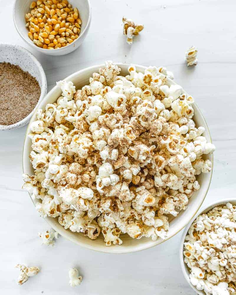 chai popcorn in a big and small bowl with seasonings in the background