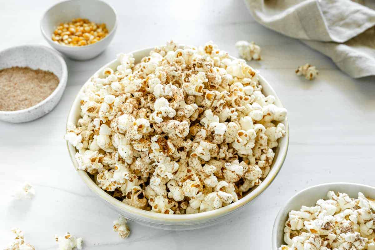 chai popcorn in a big and small bowl with seasonings in the background