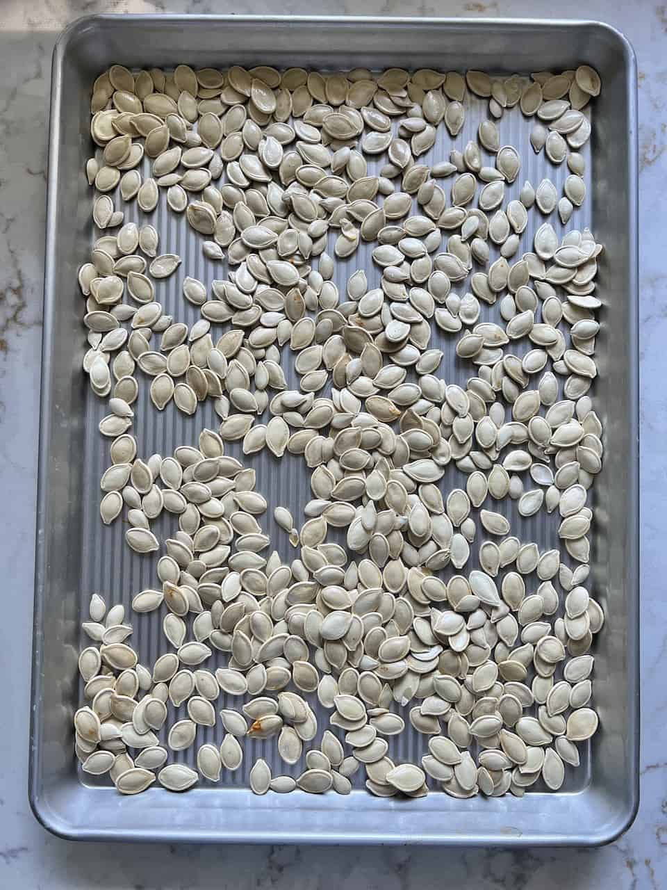 unbaked roasted spicy pumpkin seeds on a tray