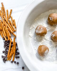 process showing pretzels and chocolate chips and peanut butter balls in a white bowl