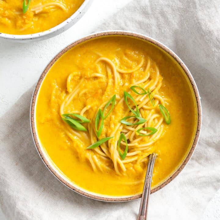 completed Curried Carrot Soup with Noodles against a white surface