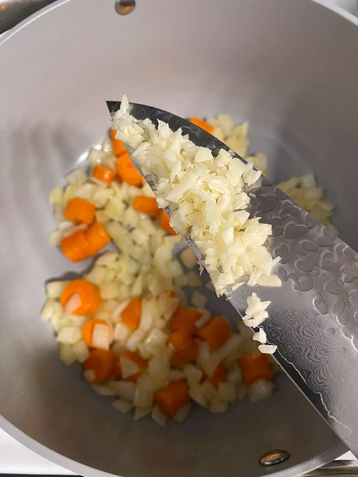 process of adding minced garlic into pan