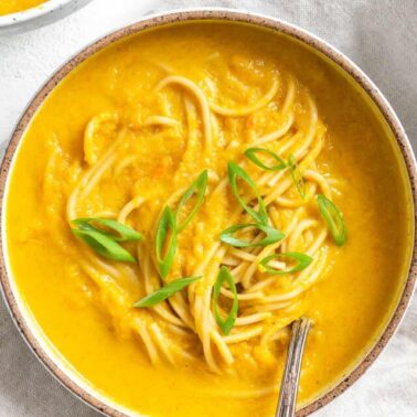 completed Curried Carrot Soup with Noodles against a white surface