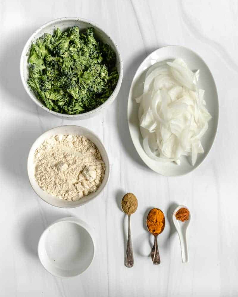ingredients for broccoli and onion pakora on a white surface