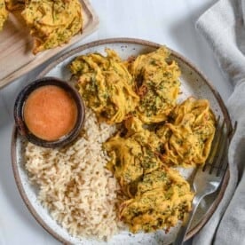 completed broccoli and onion pakora plated with rice and a sauce