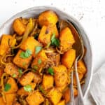 completed Roasted Butternut Squash with Indian Spices and Caramelized Onions in a serving tray against white background