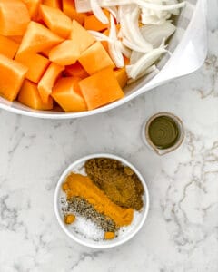 ingredients for Roasted Butternut Squash with Indian Spices and Caramelized Onions on a white marble surface