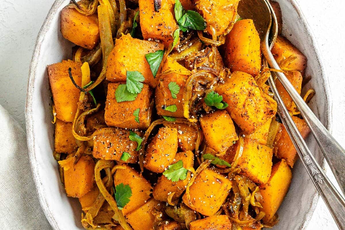 completed Roasted Butternut Squash with Indian Spices and Caramelized Onions in a serving tray against white background