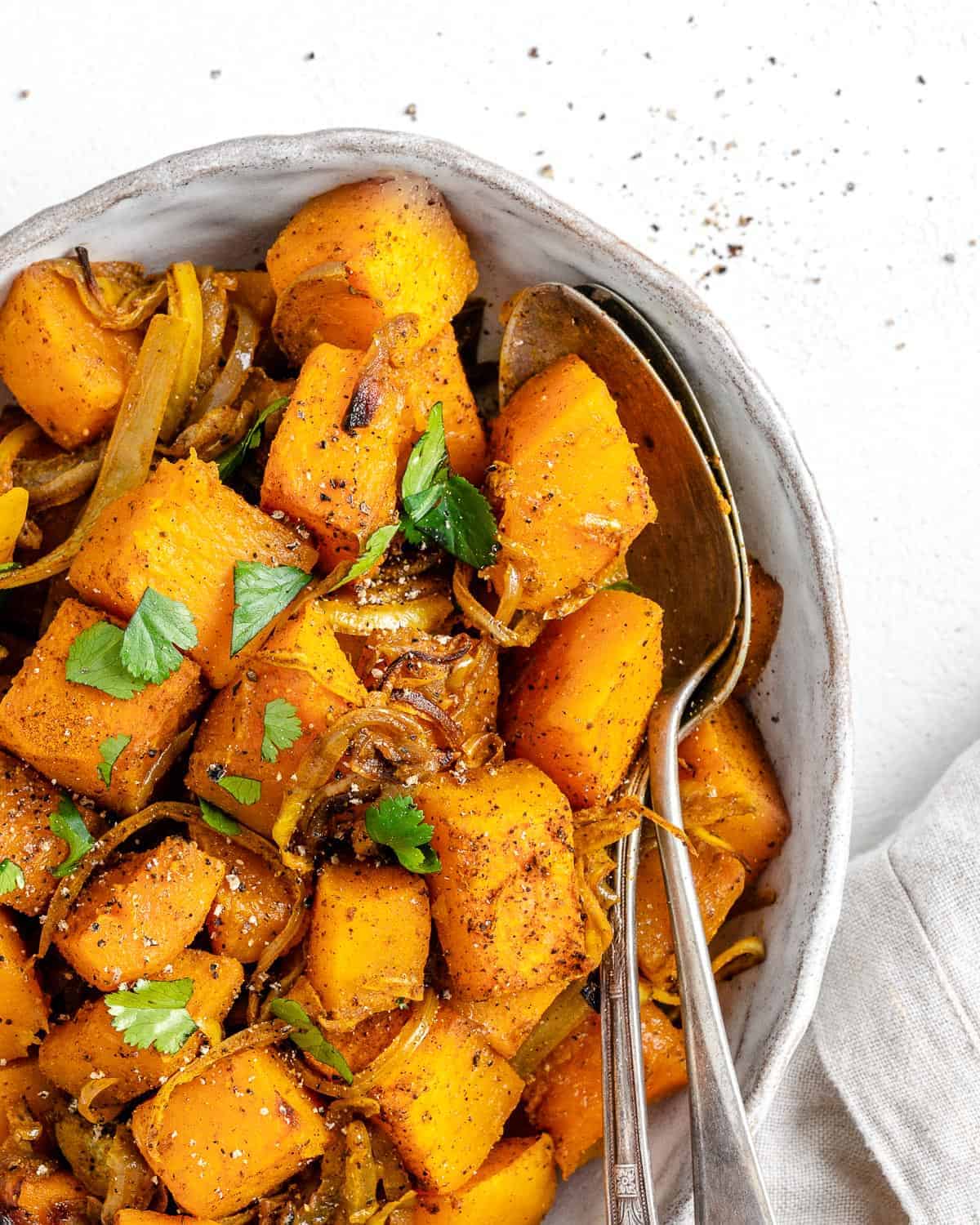 completed Roasted Butternut Squash with Indian Spices and Caramelized Onions in a serving tray against white background