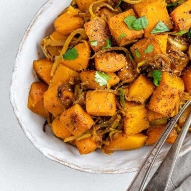 completed Roasted Butternut Squash with Indian Spices and Caramelized Onions in a serving tray against white background
