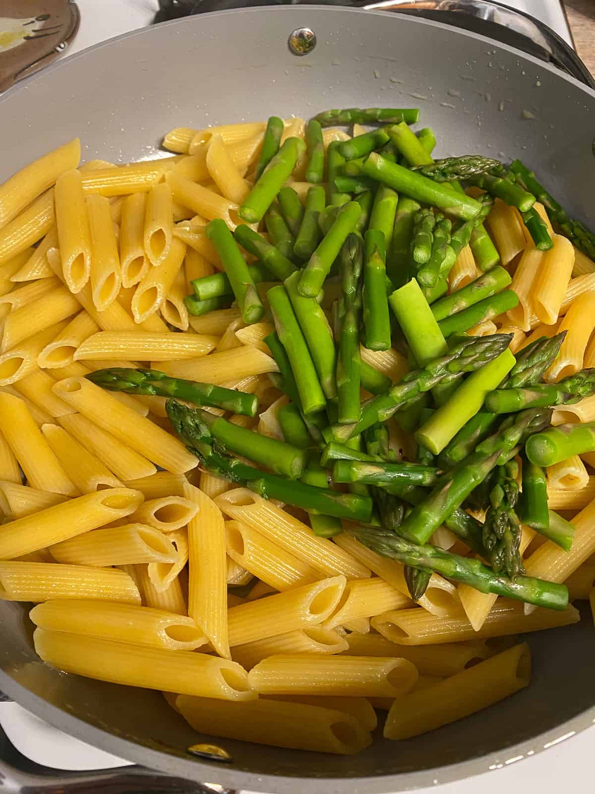 process shot of adding asparagus to pasta