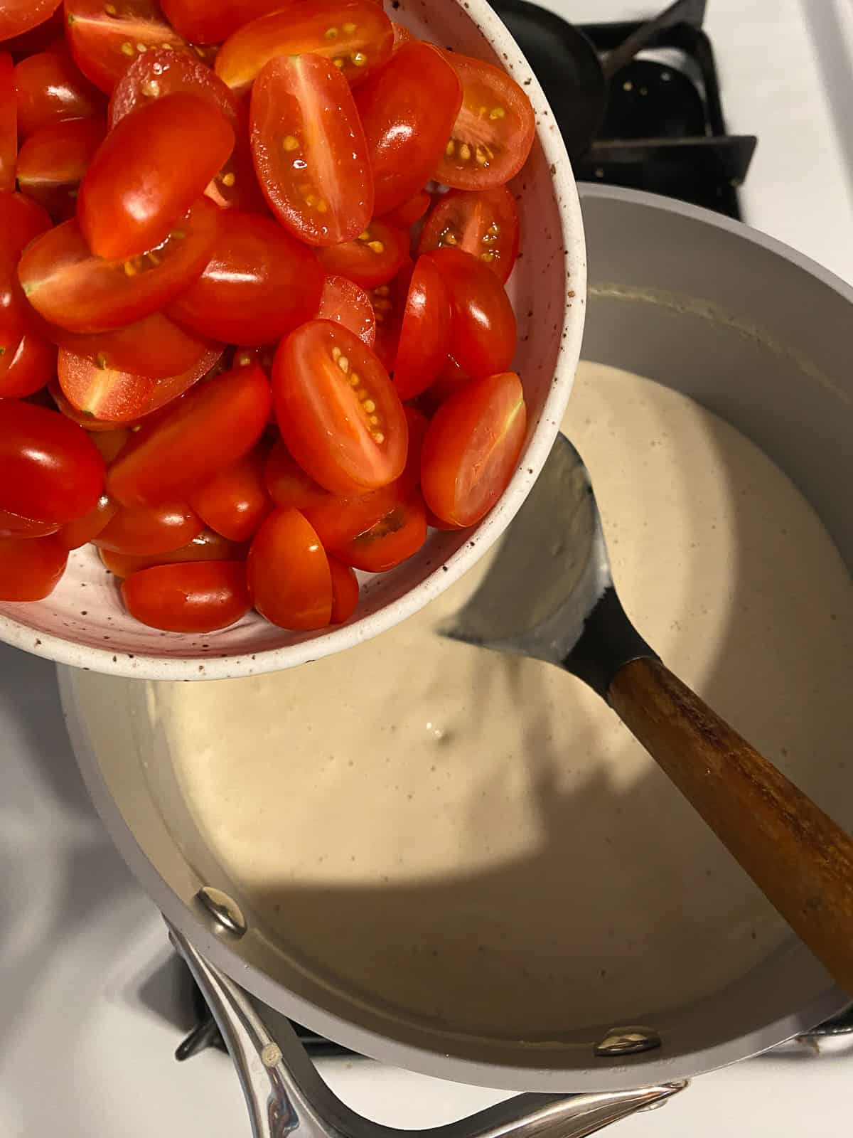 process shot of adding tomatoes to a pot