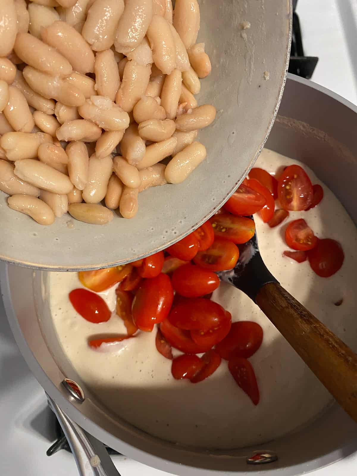 process shot of adding beans to sauce