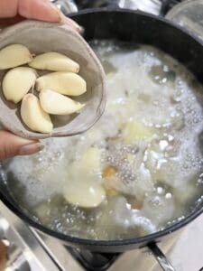 process of adding garlic into vegan mashed potatoes