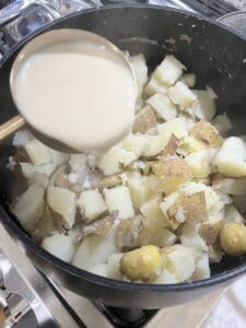 process of adding plant-based milk into vegan mashed potatoes