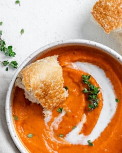 completed Vegan Tomato Bisque with Thyme in a white bowl against a light background