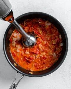 process shot of using immersion blender into black pan