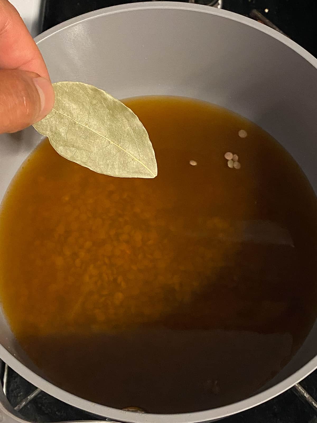 process shot of adding bay leaf to pot