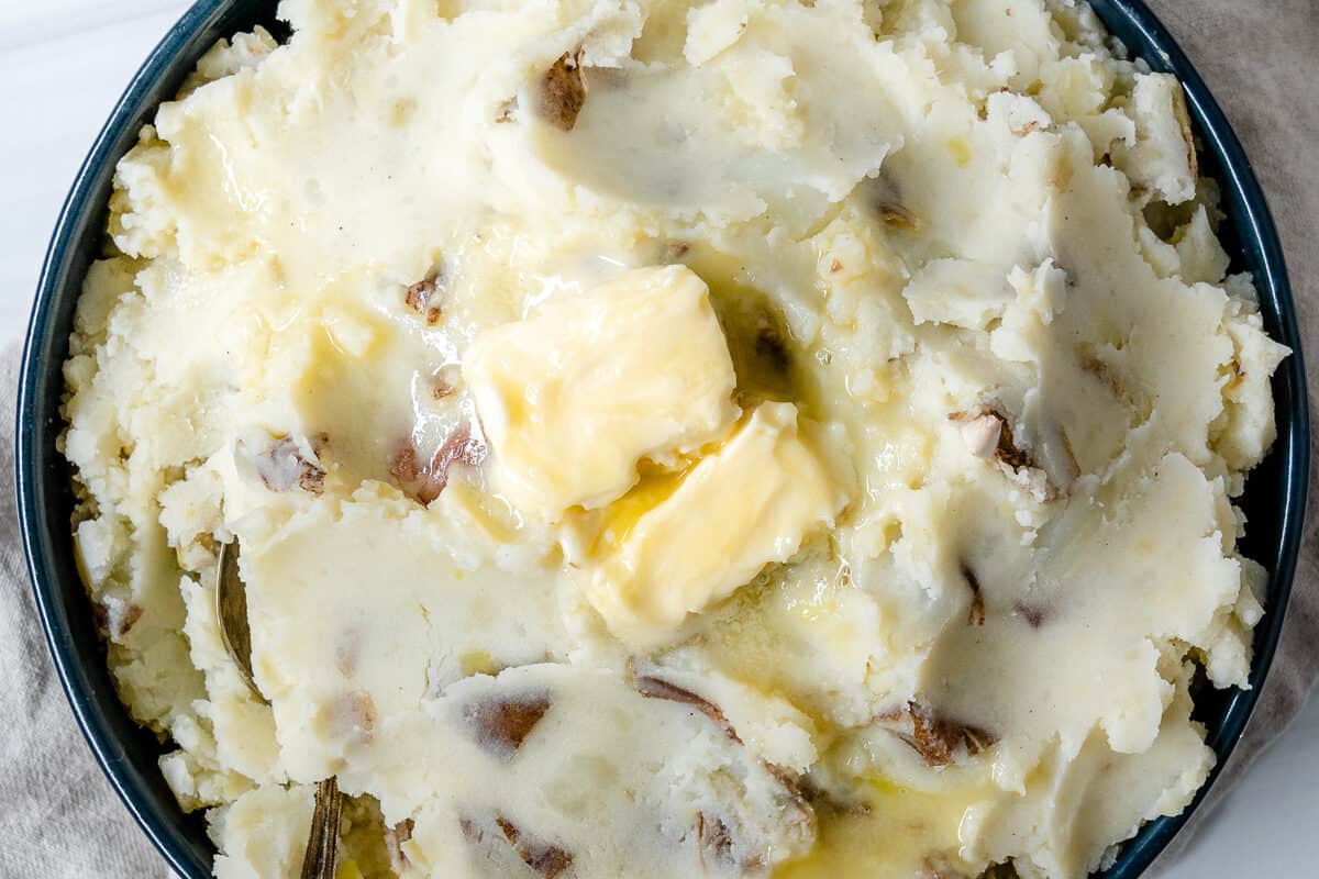 completed vegan mashed potatoes plated against white surface