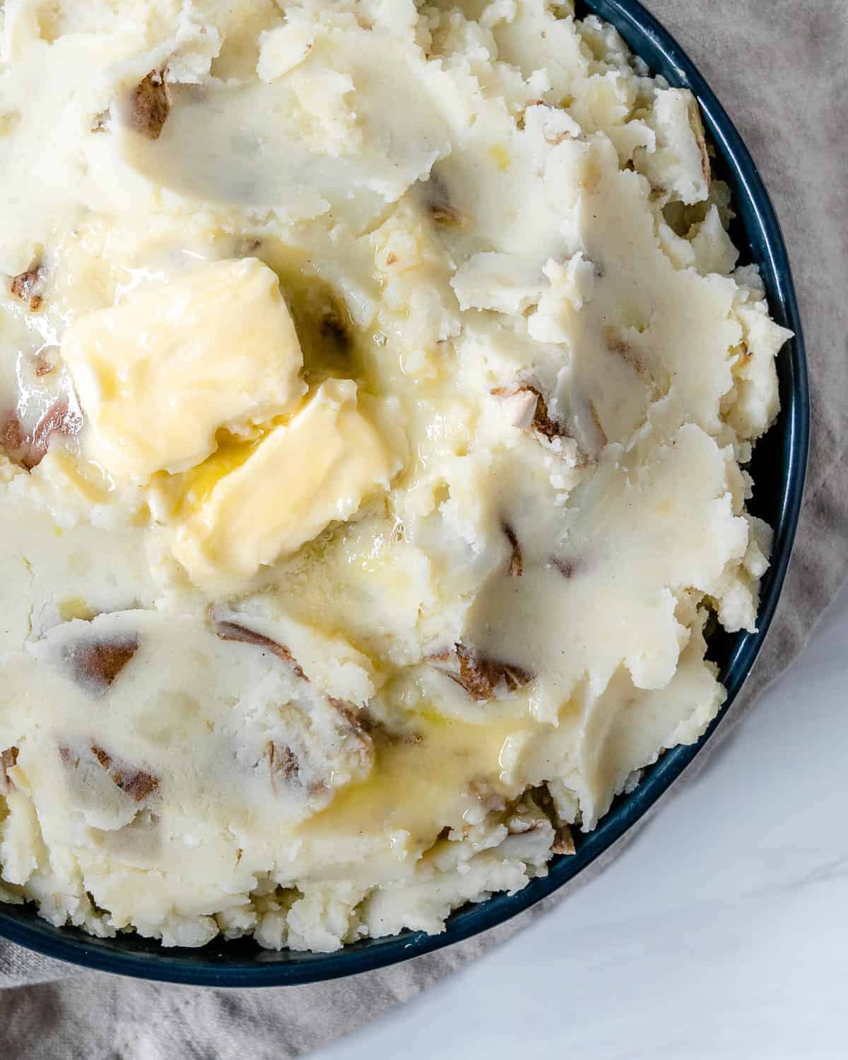 completed vegan mashed potatoes plated against white surface
