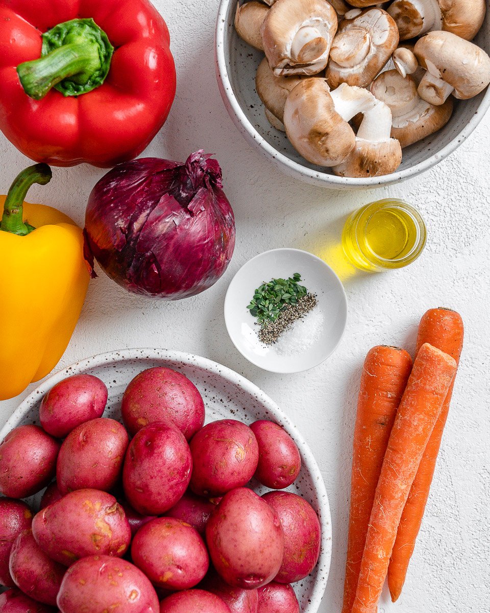 ingredients for Vegan Roasted Vegetables with Thyme spread out on a white surface