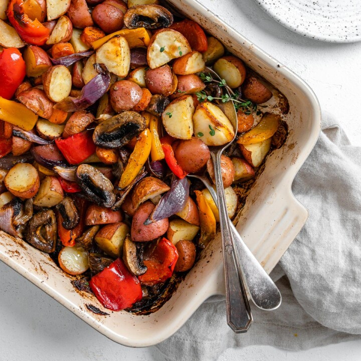 completed Vegan Roasted Vegetables with Thyme in a baking dish against a white background