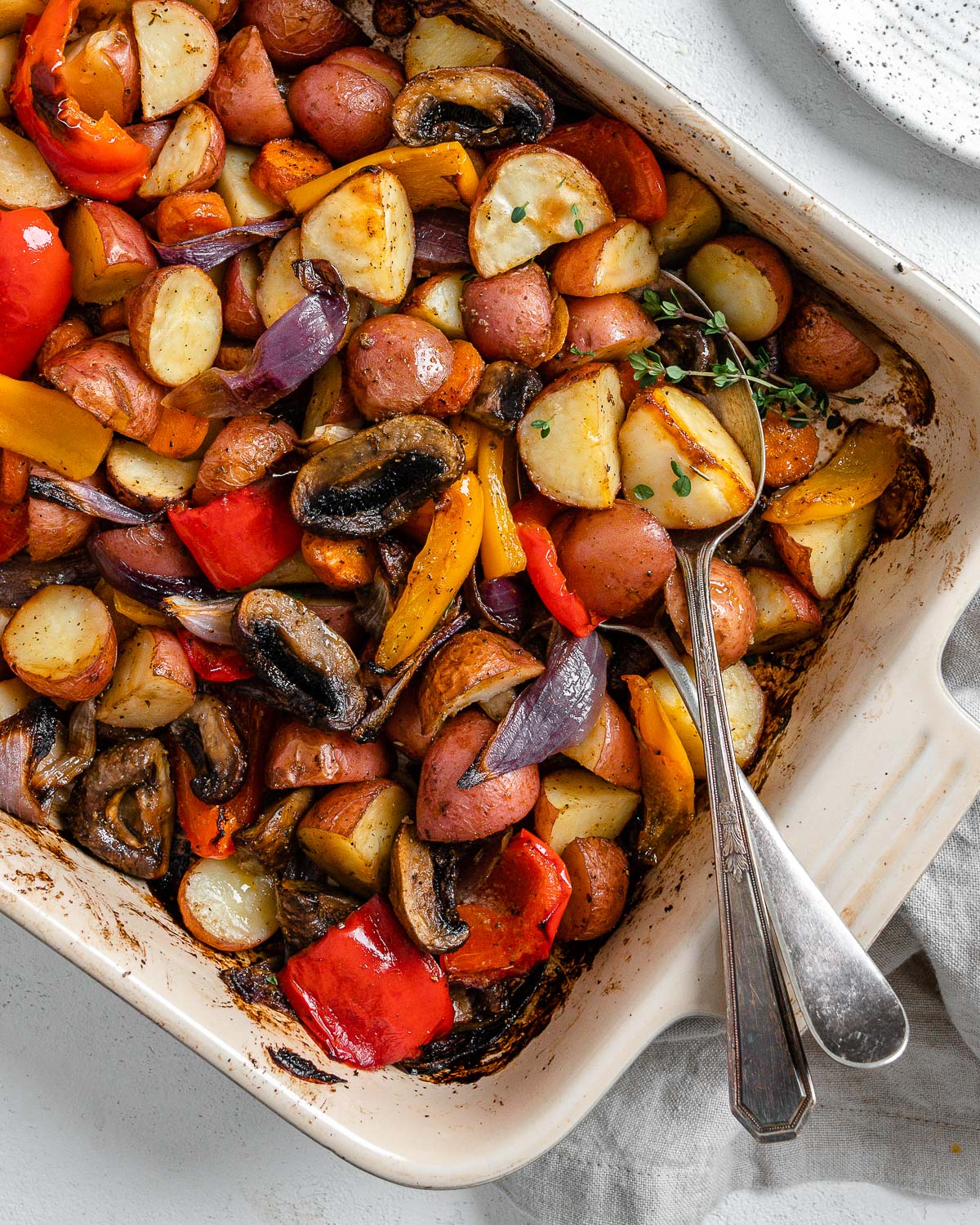 completed Vegan Roasted Vegetables with Thyme in a baking dish against a white background