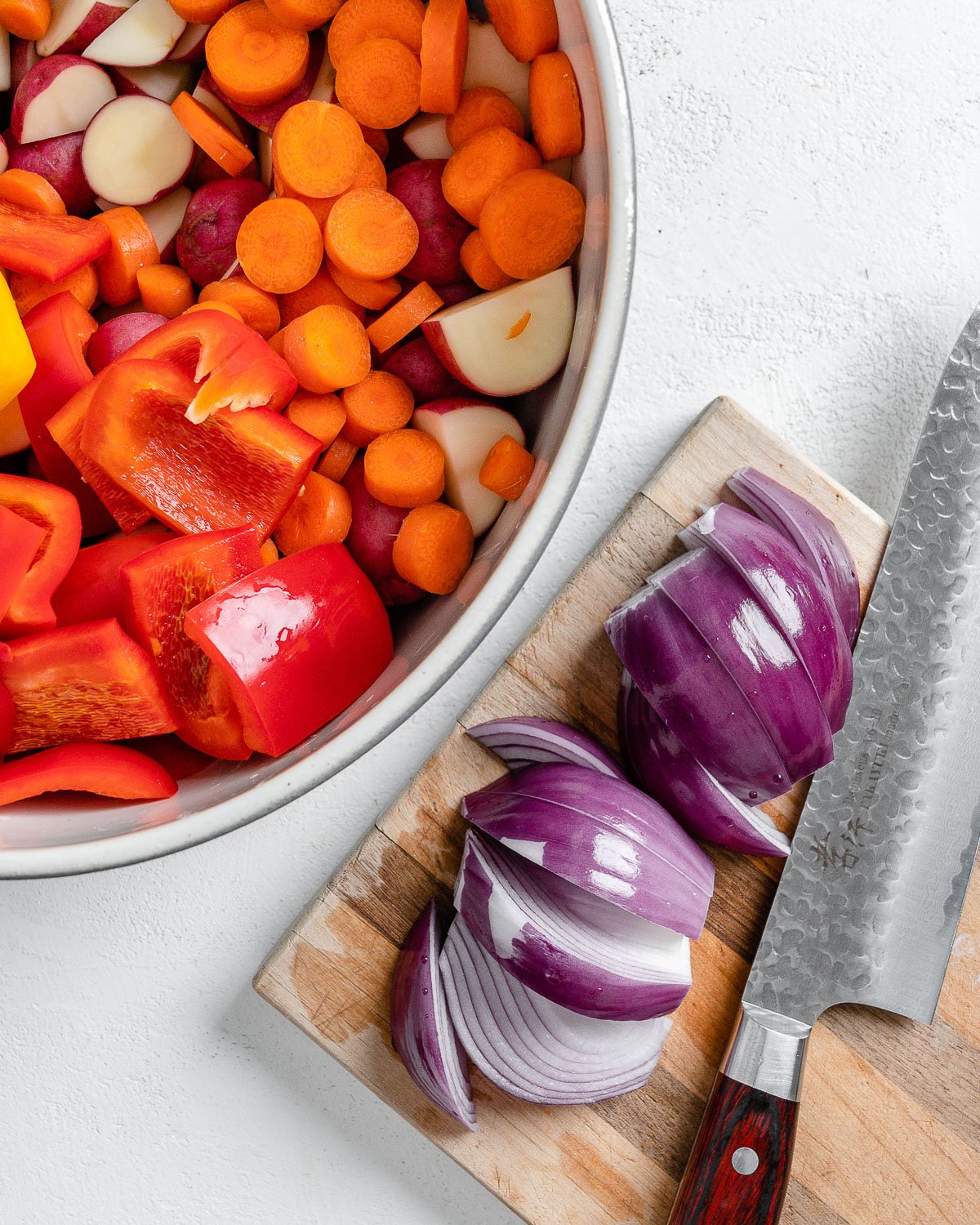 post slicing onions on cutting board alongside bowl of veggies