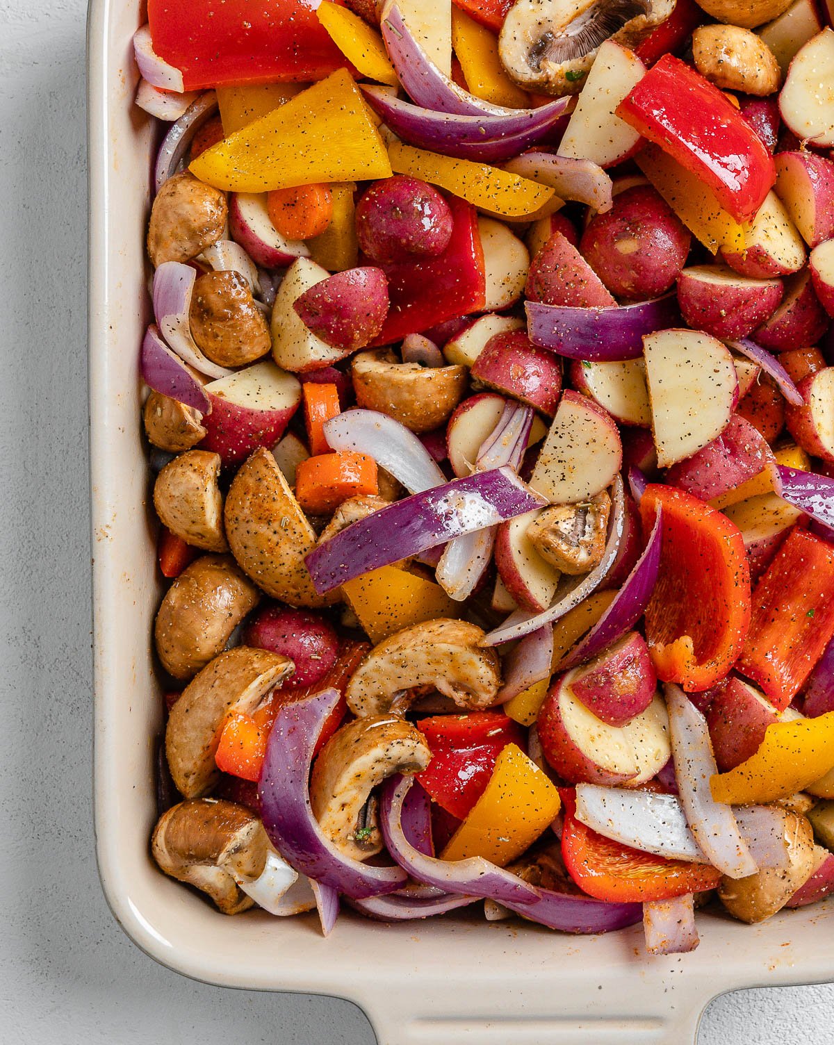 pre cooked Vegan Roasted Vegetables with Thyme in a baking dish against a white background