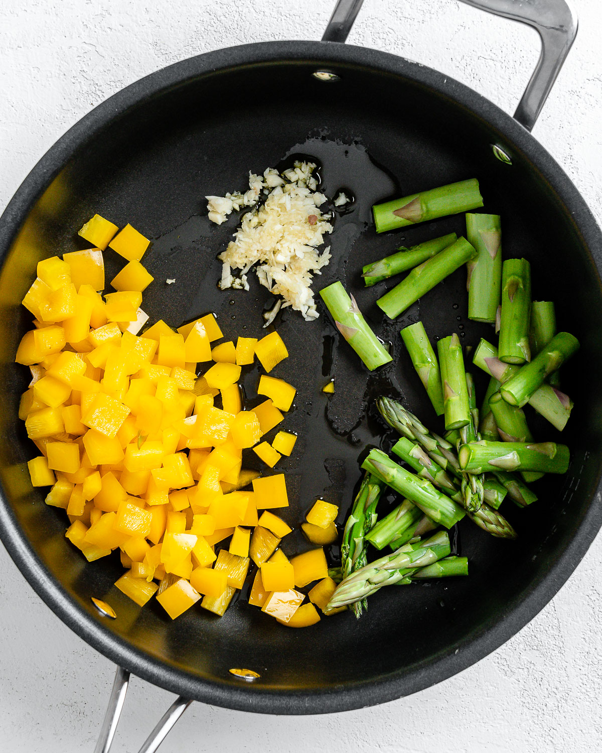 the addition of veggies and spices into black pan