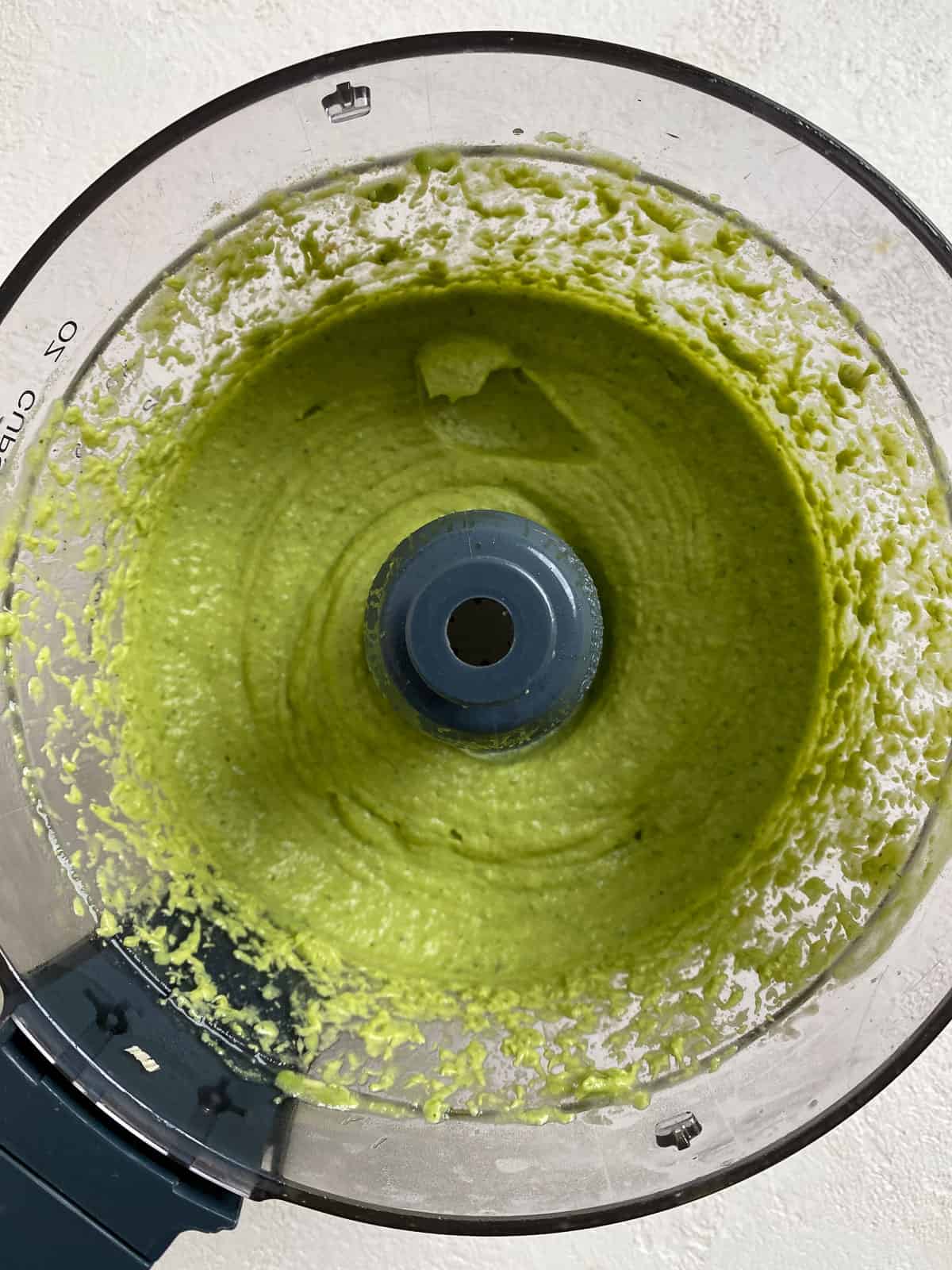 process shot showing blended avocado cream in food processor