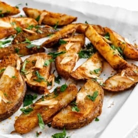 completed Oven Baked Garlic Parsley Fries scattered on a baking tray