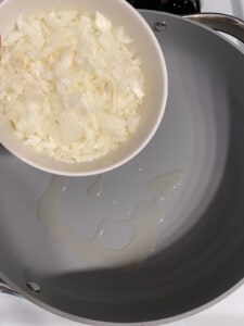 process shot of adding onions to pan