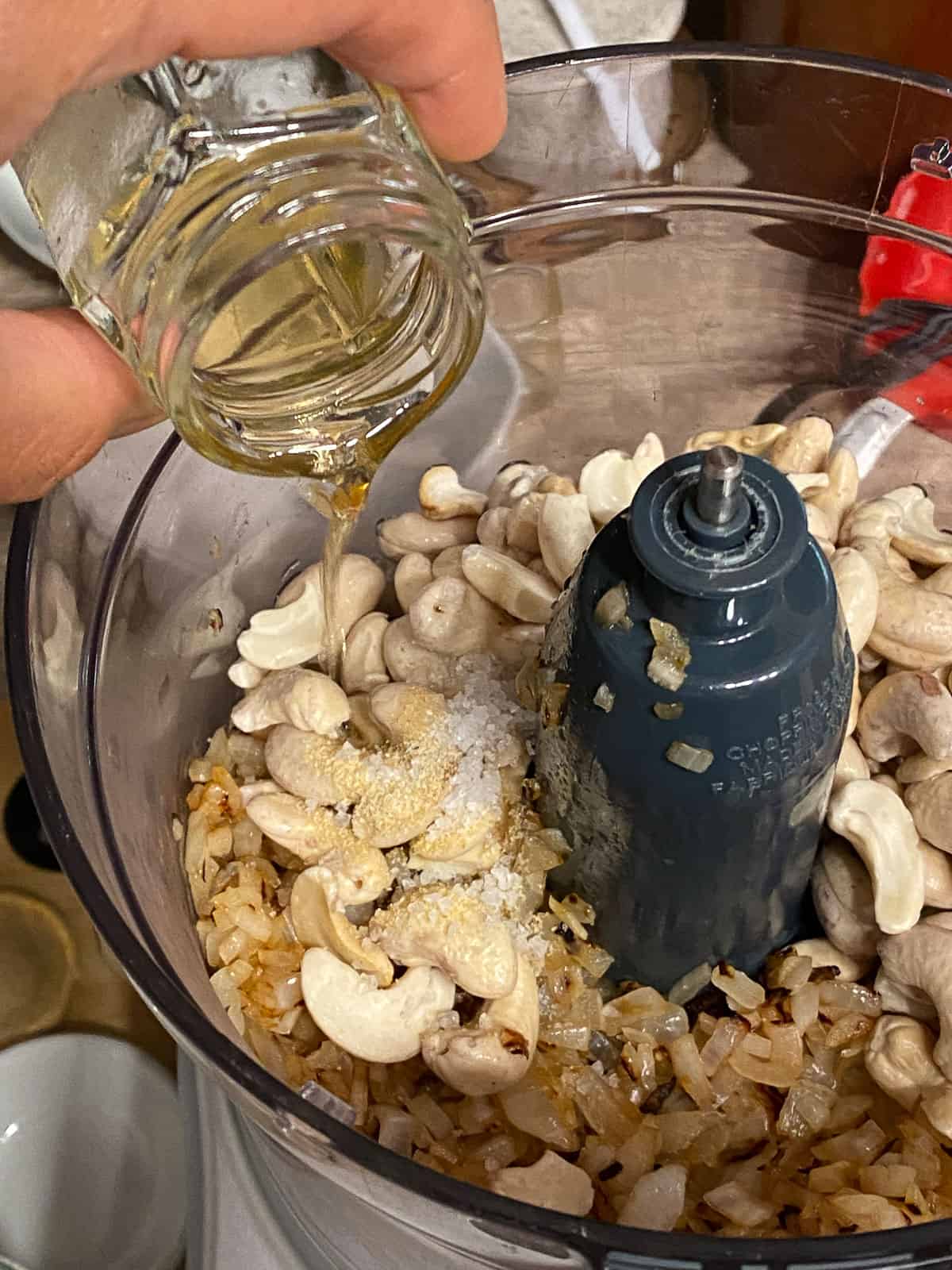 process shot of adding oil to food processor