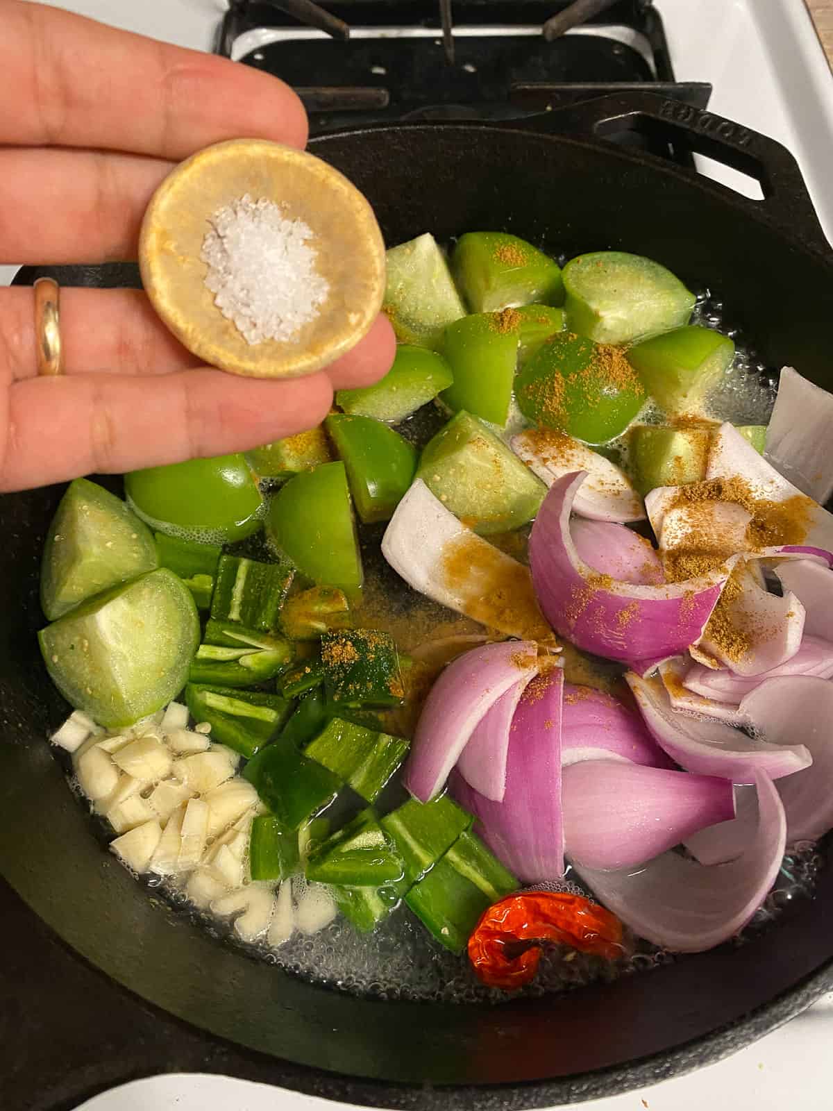process of adding salt to pan of veggies