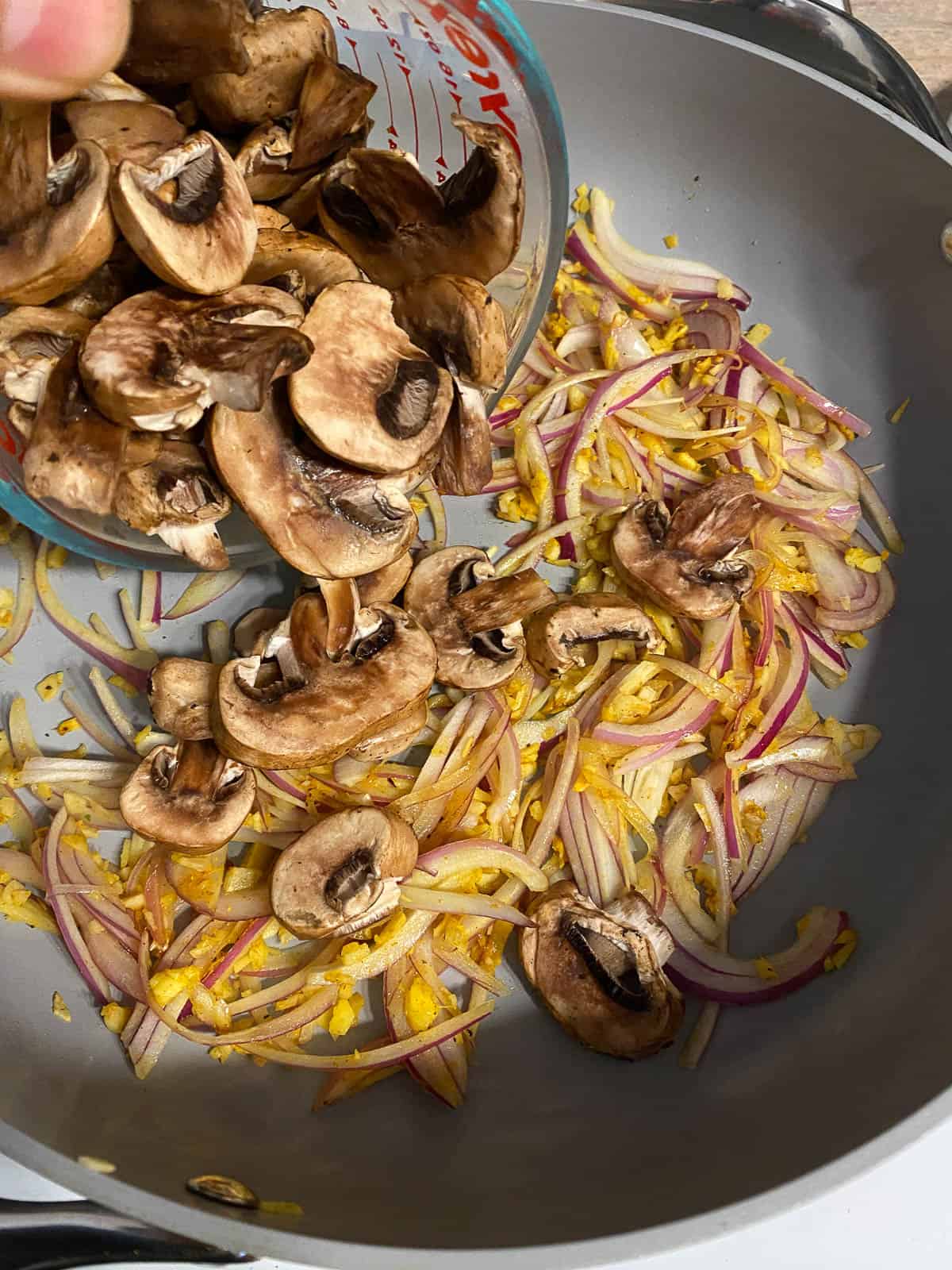 process of adding mushrooms to pan