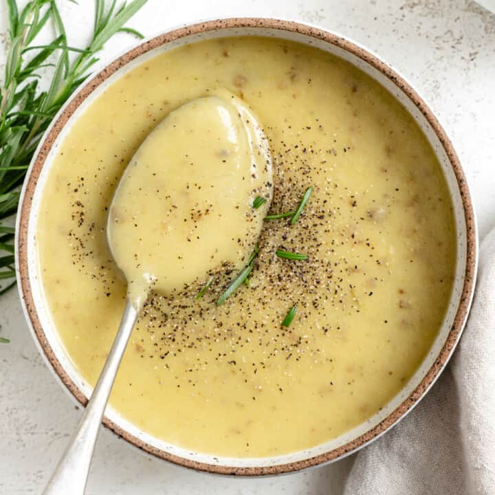 completed Creamy Vegan Potato Leek Soup in a bowl against a light background