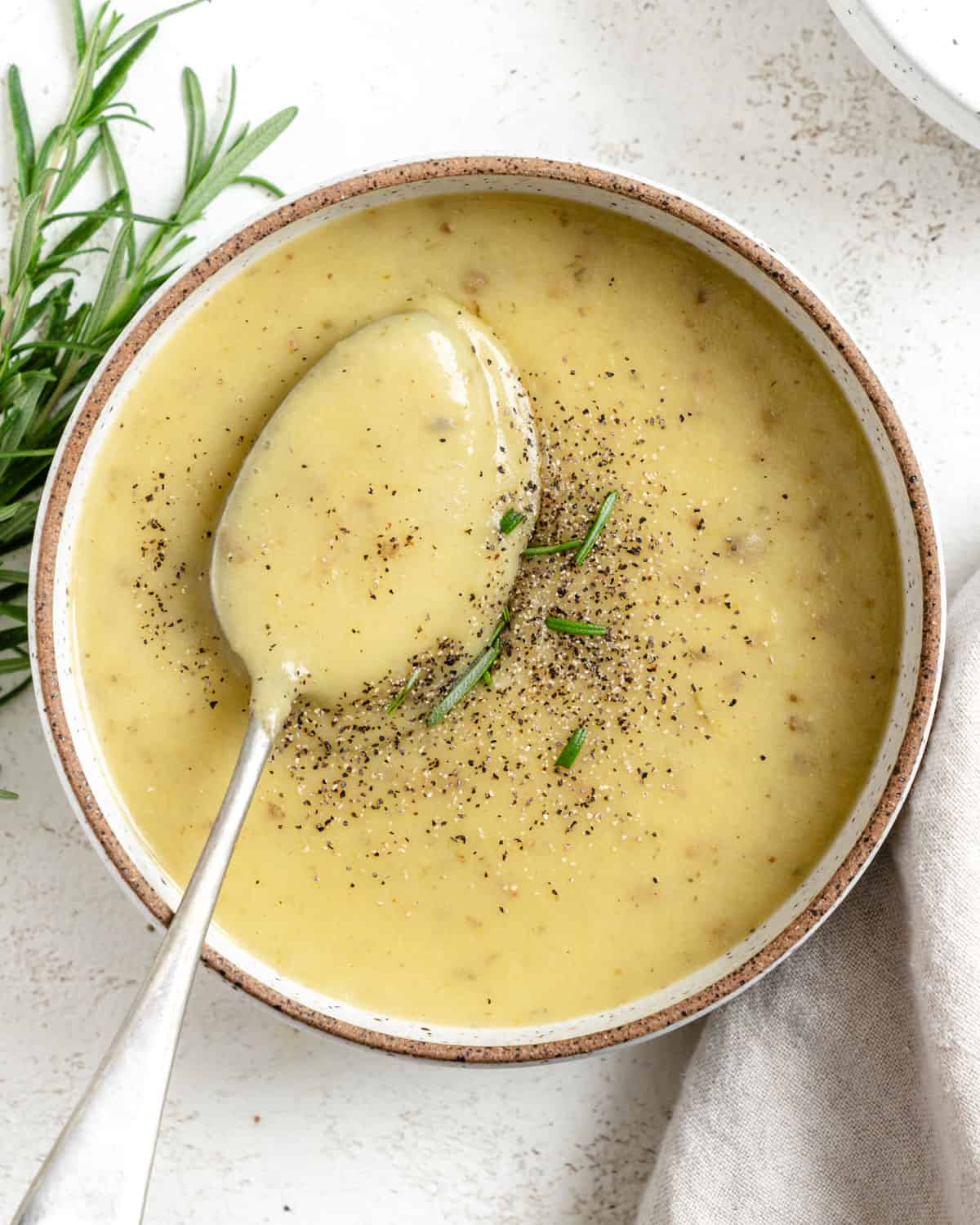 completed Creamy Vegan Potato Leek Soup in a bowl against a light background